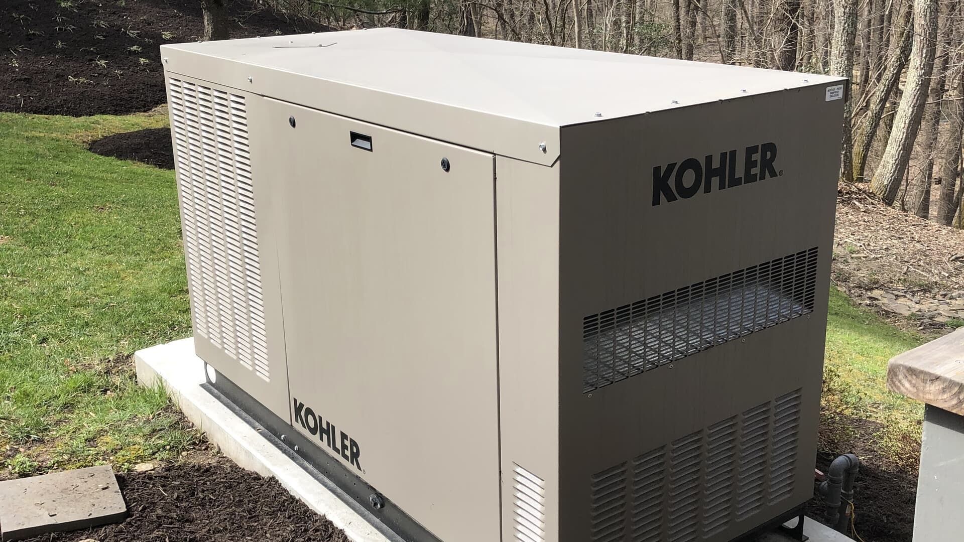 Beige Kohler home generator outdoors on a grassy lawn near a house