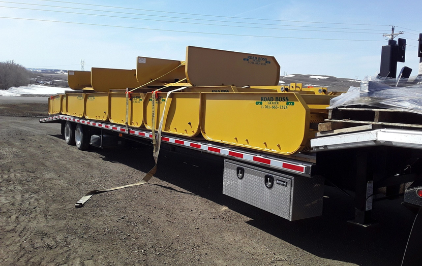 A large yellow trailer with a tractor on it