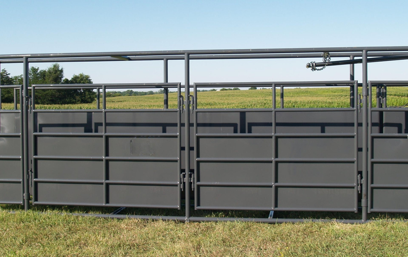 A metal fence is sitting in the middle of a grassy field.