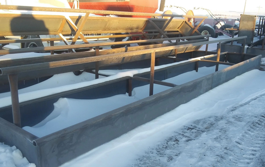 A row of concrete troughs in the snow