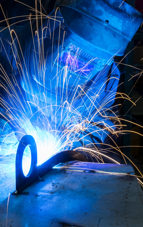 A person is welding a piece of metal with sparks coming out of it