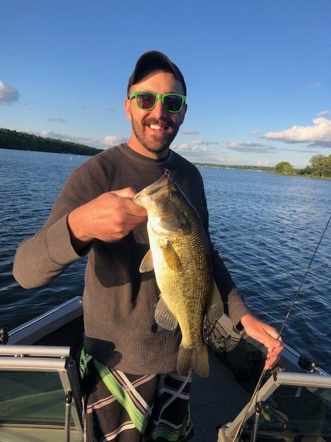 A man on a boat holding a large fish