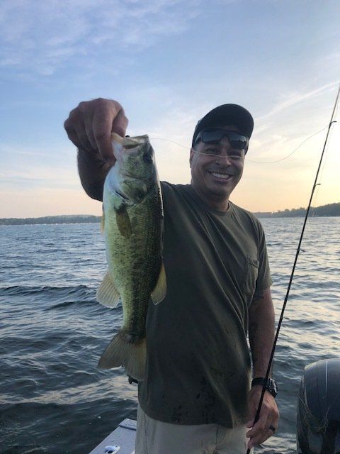 A man on a boat holding a fish in his hand