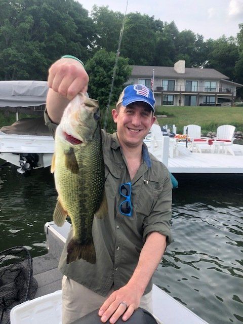 A man on a boat holding a large fish