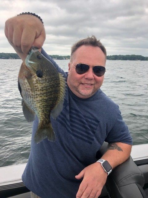 A man on a boat holding a fish in his hand