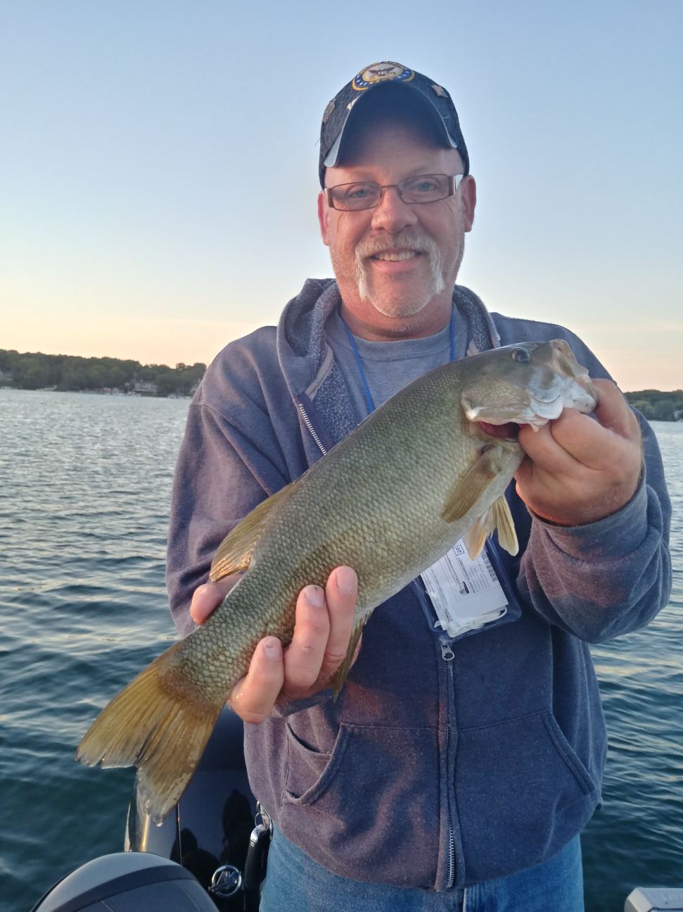 A man is holding a fish in his hands on a boat.