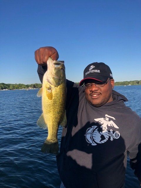 A man is holding a large fish on a boat.