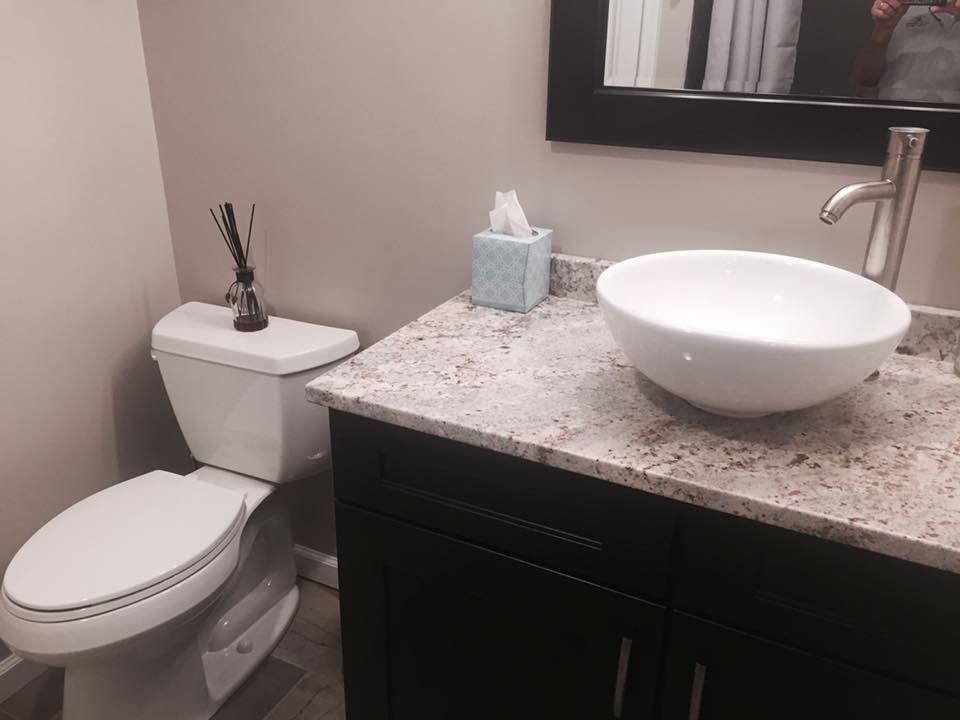 A bathroom with a toilet a sink and a mirror