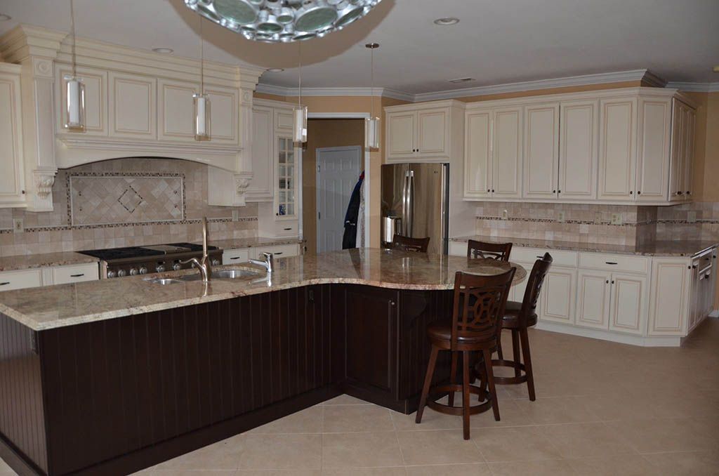 A kitchen with white cabinets and a large island
