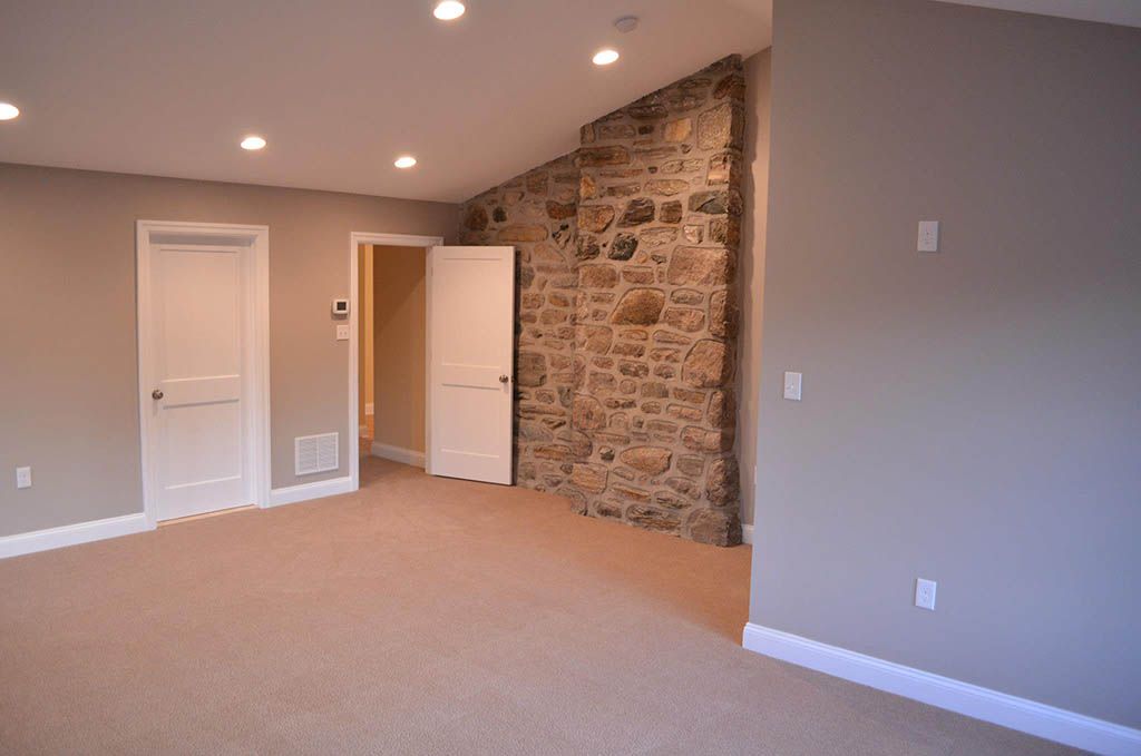 An empty room with a stone wall and a fireplace.
