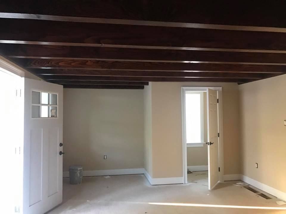 An empty room with wooden beams and a door