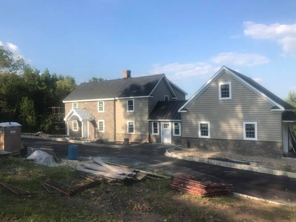 Two houses are being built next to each other on a sunny day.