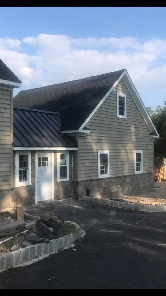 A house with a black roof and white windows is being built.