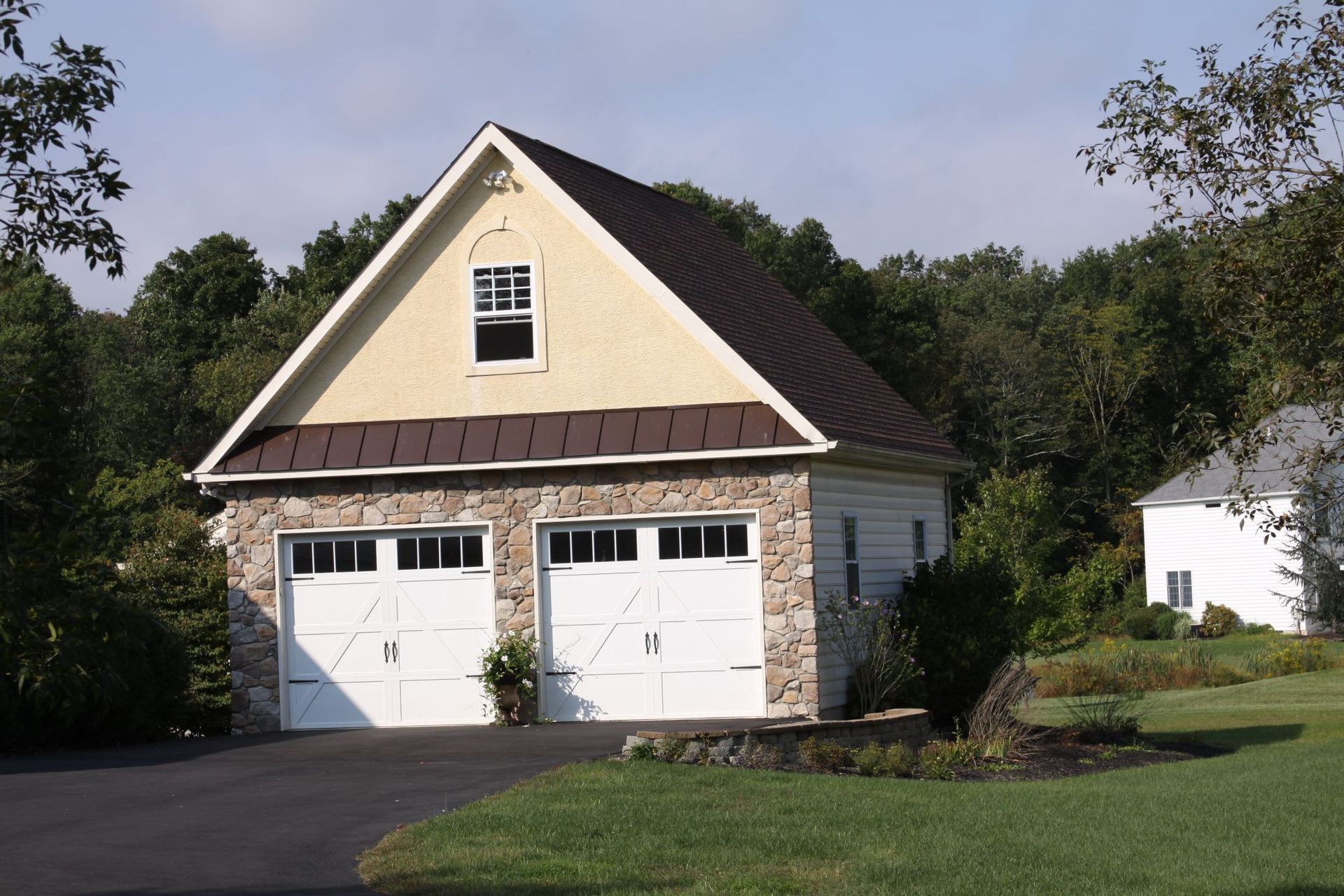 A white garage with a brown roof and white doors