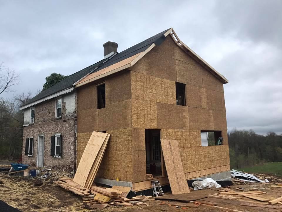 A house is being built with plywood and a roof.