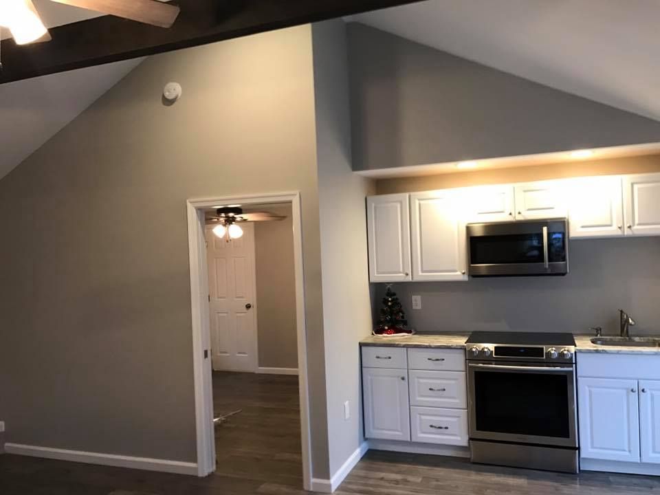 A kitchen with white cabinets and stainless steel appliances
