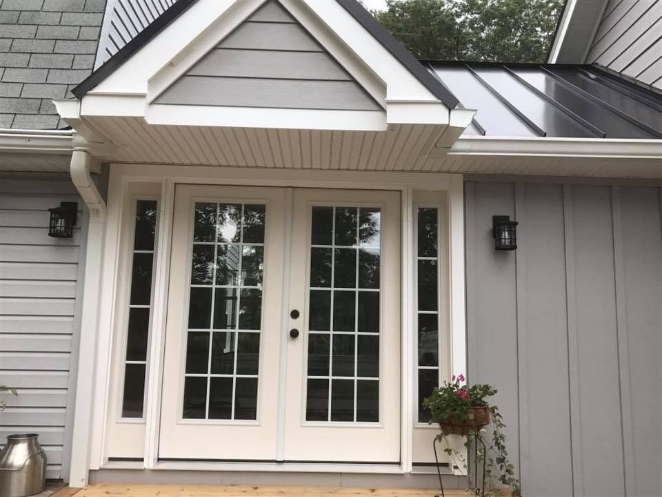 The front door of a house with a black roof
