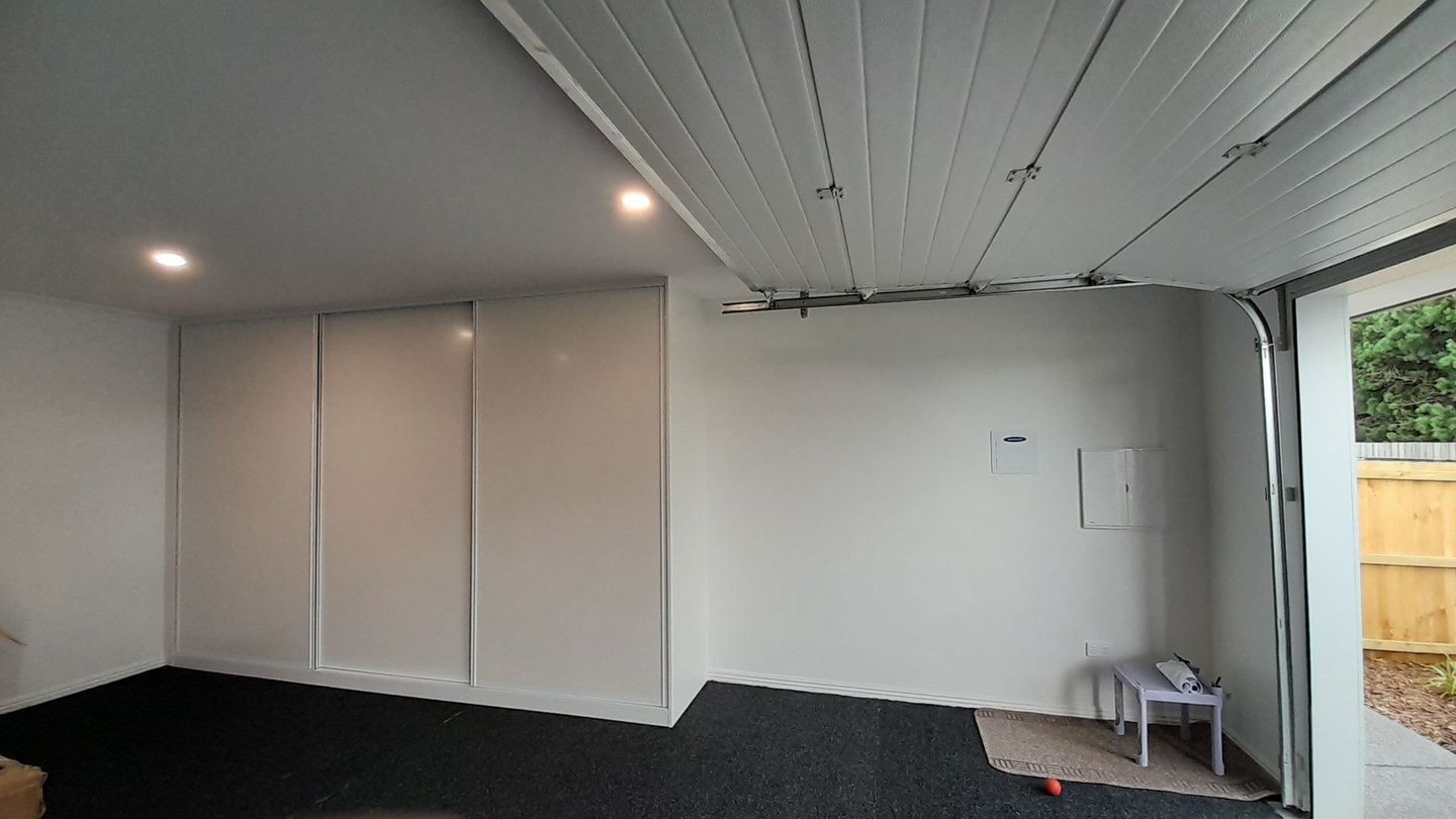 A garage with a sliding garage door and white walls.