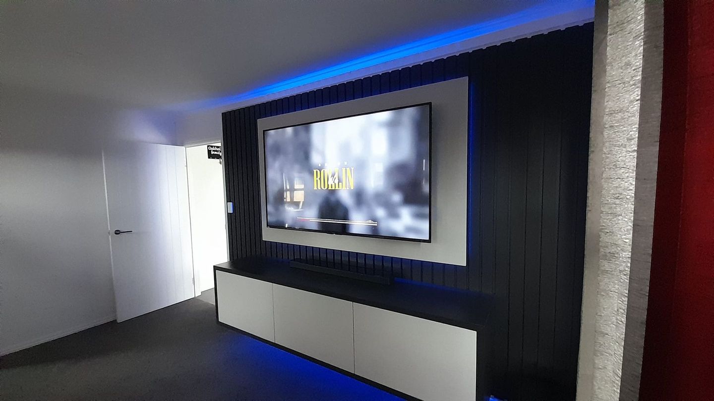 A living room with a flat screen tv mounted on the wall.