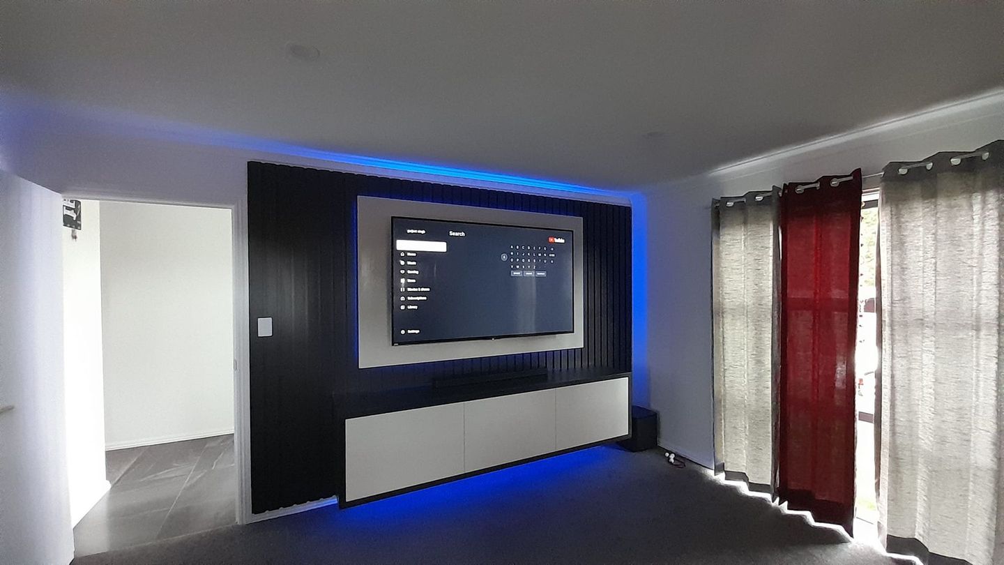 A living room with a flat screen tv on the wall.