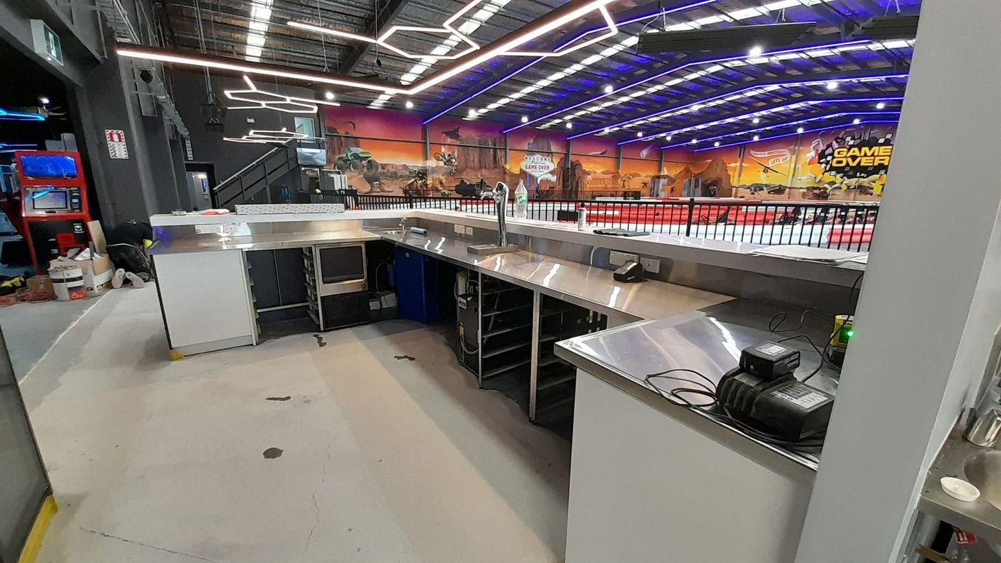 A large stainless steel counter in a room with a painting on the wall.