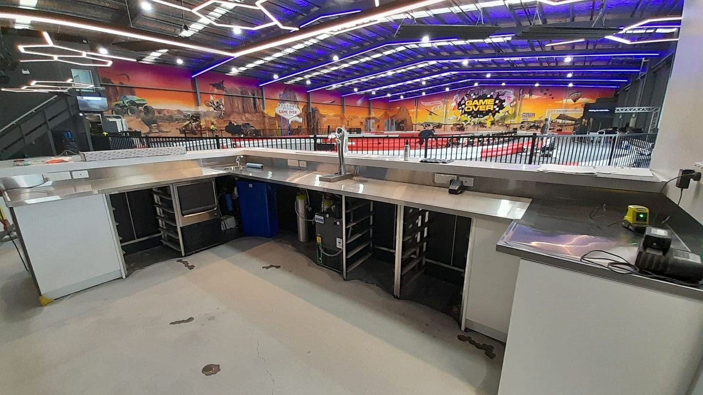 A kitchen with stainless steel counter tops and a mural on the wall.