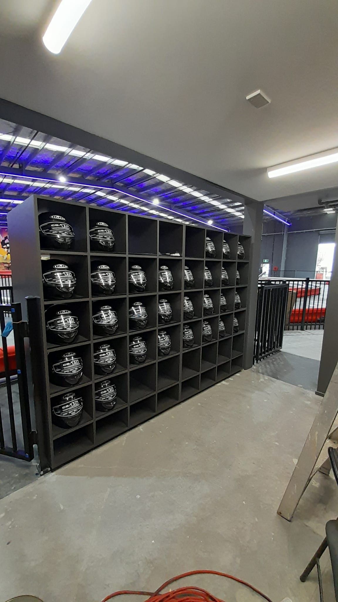 A room filled with lots of helmets on shelves.