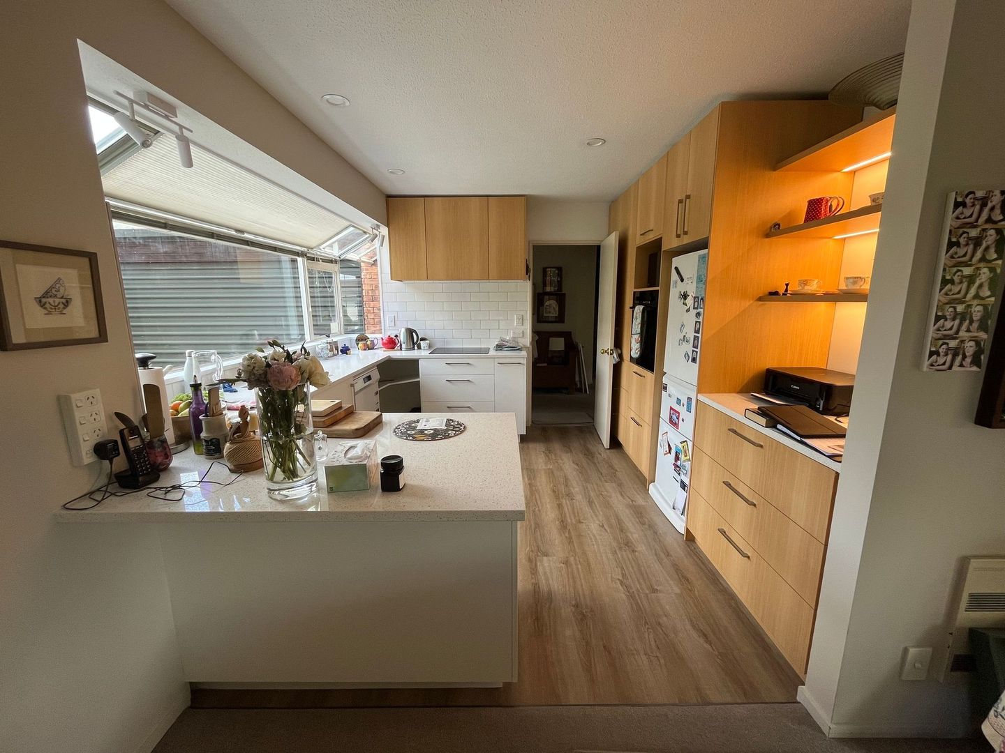 A kitchen with wooden cabinets and a large window.