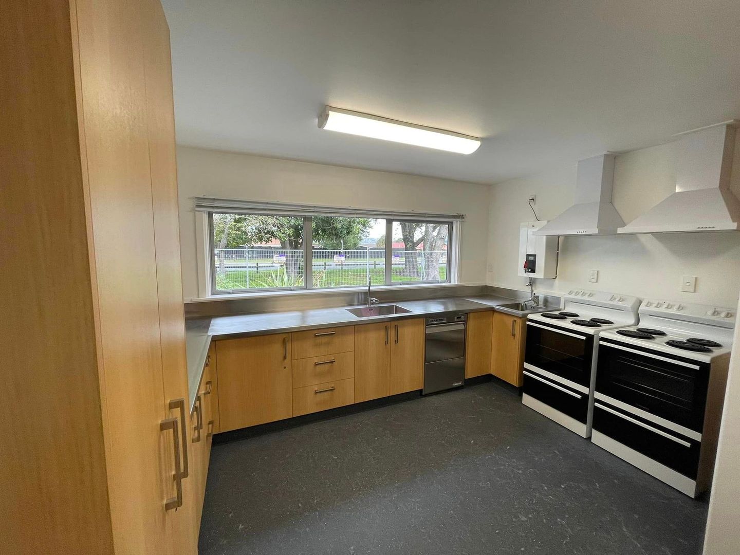 A kitchen with wooden cabinets , a stove and a sink