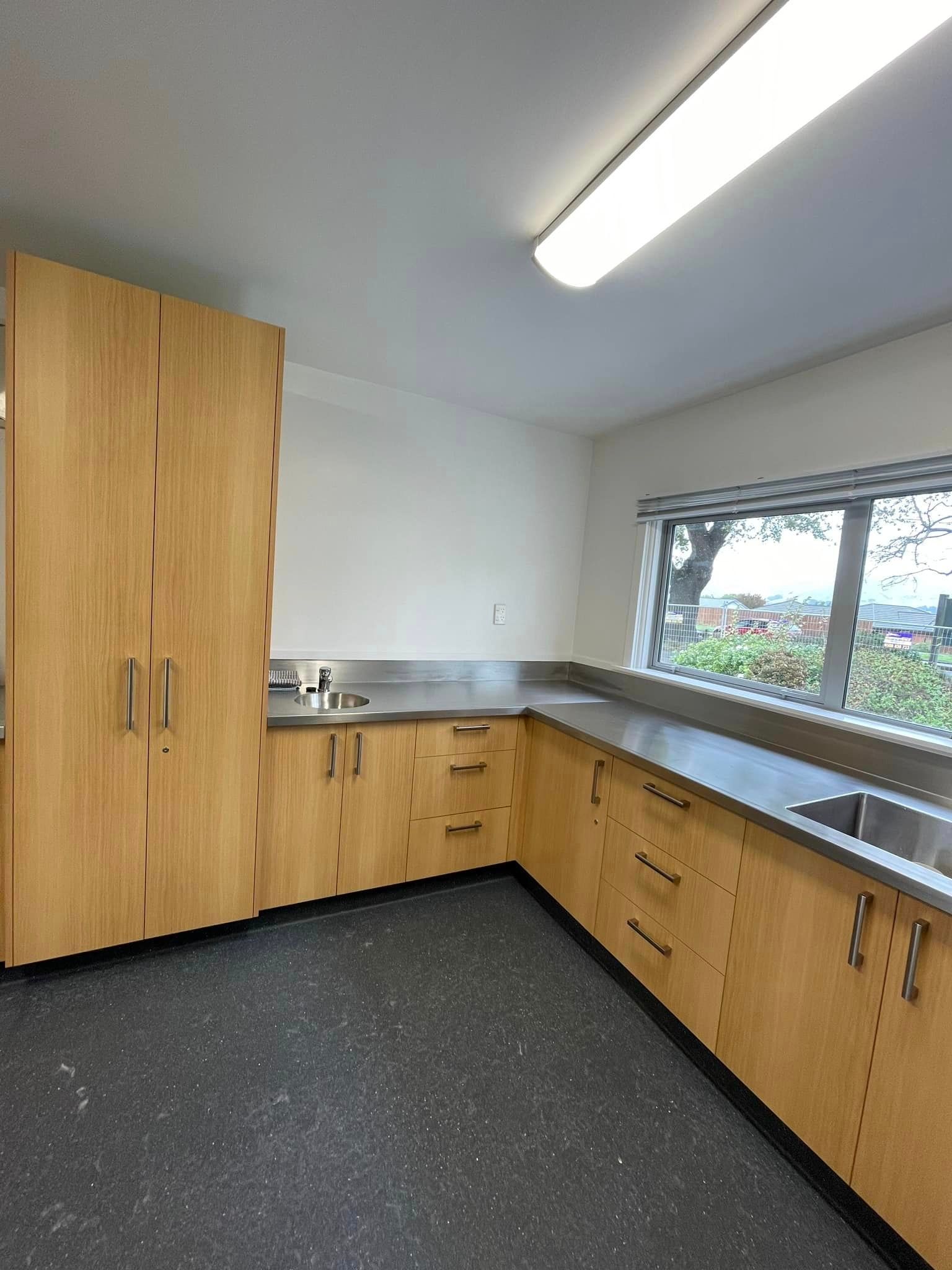 A kitchen with wooden cabinets and stainless steel counter tops