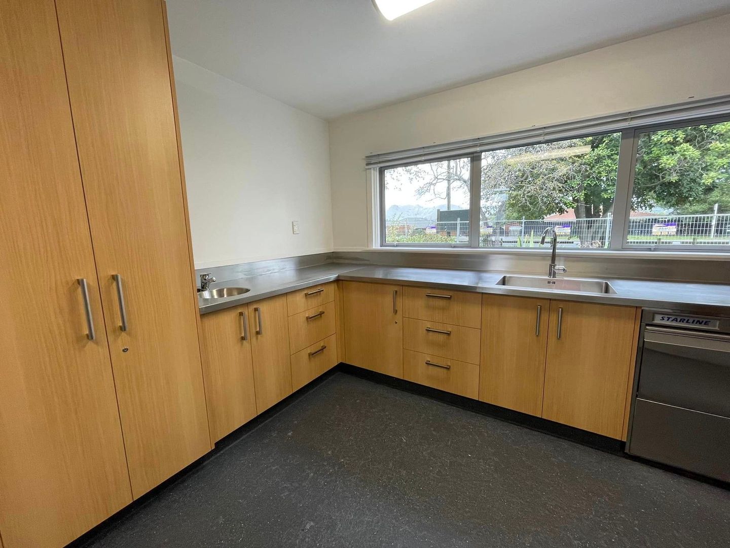 A kitchen with wooden cabinets and stainless steel counter tops