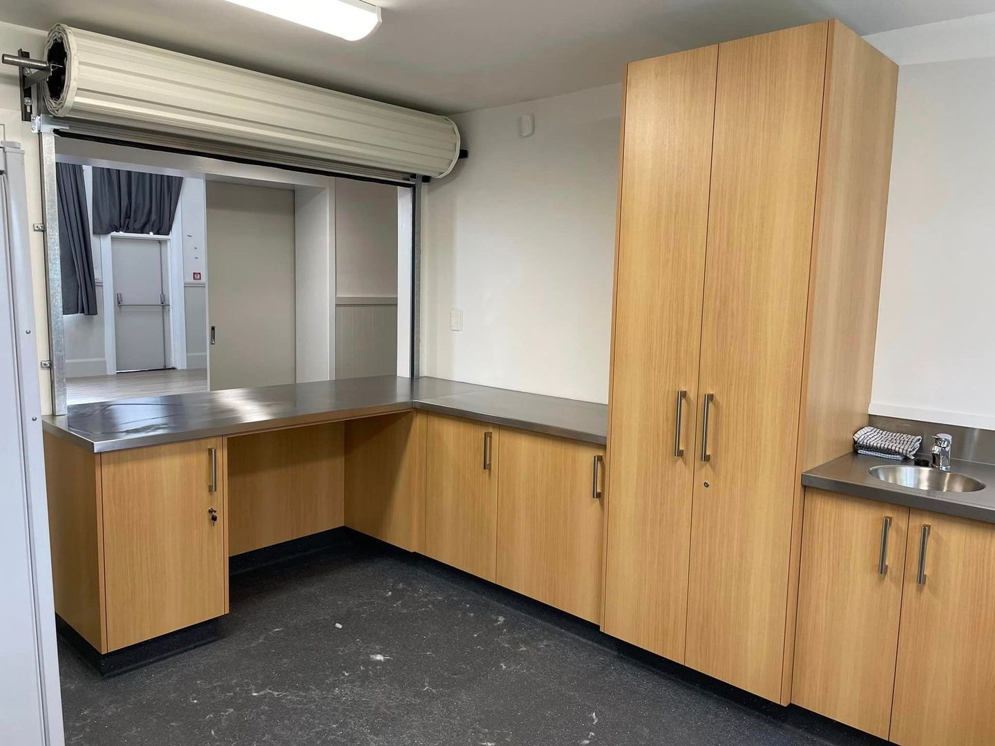 A kitchen with wooden cabinets and a stainless steel counter top.