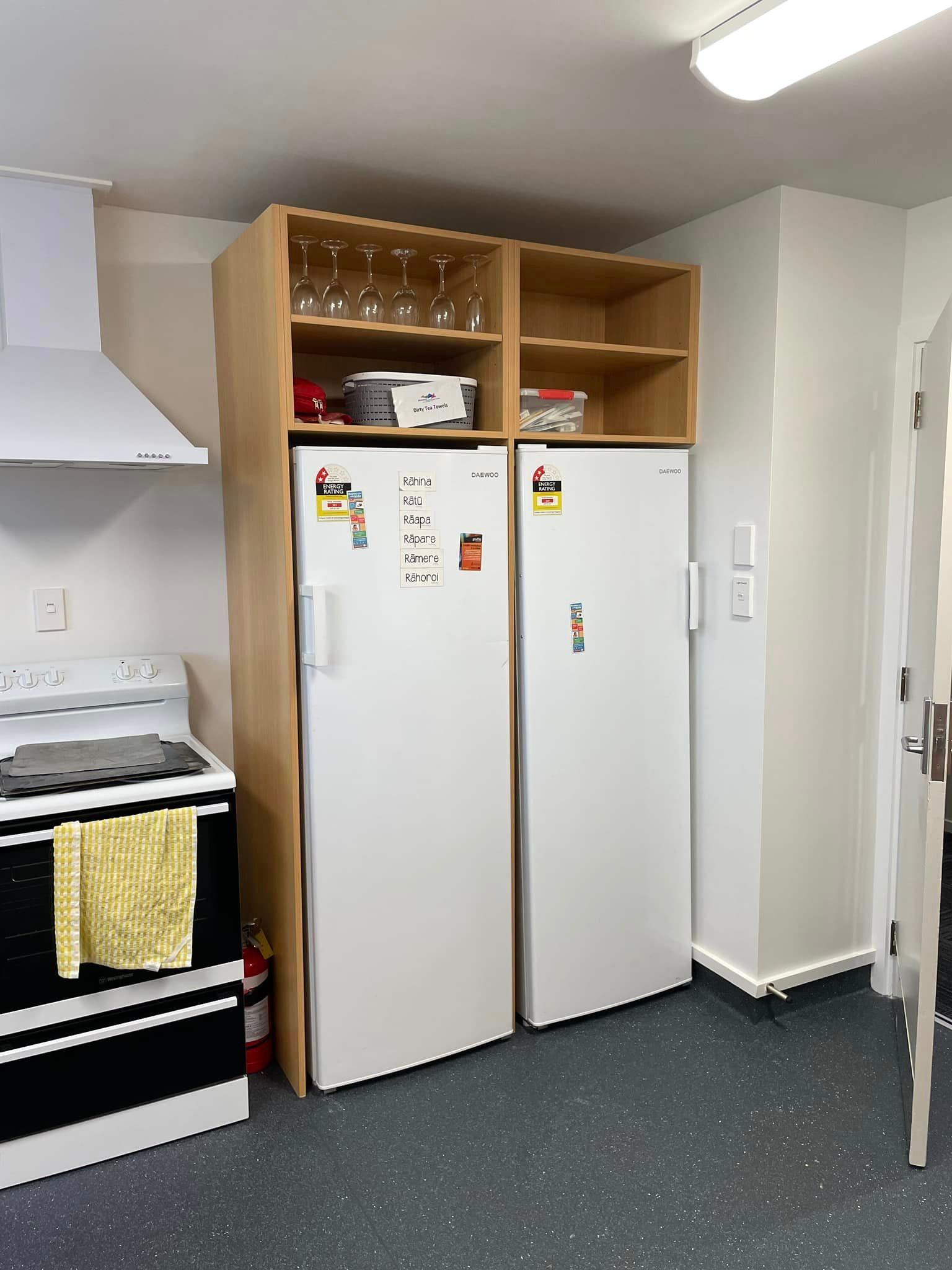 A kitchen with two white refrigerators and a stove