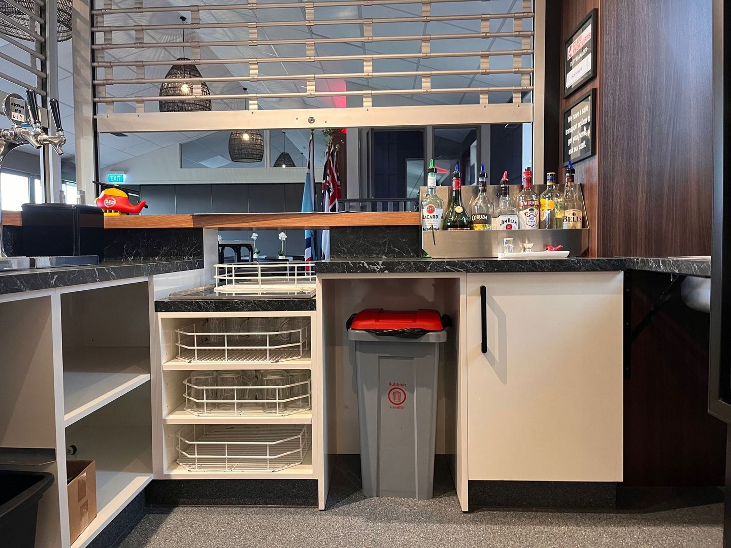 A kitchen with a trash can underneath the counter.