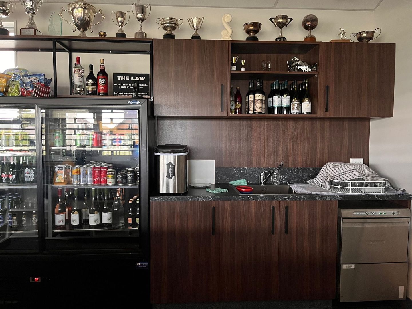 A kitchen with trophies on the wall and a sign that says the la