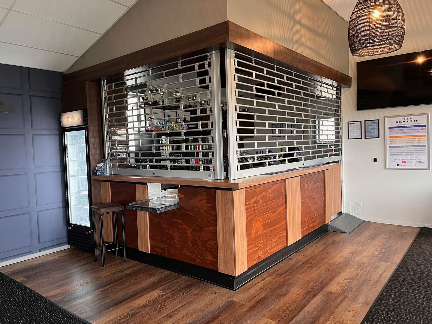 A room with a bar and a refrigerator in it