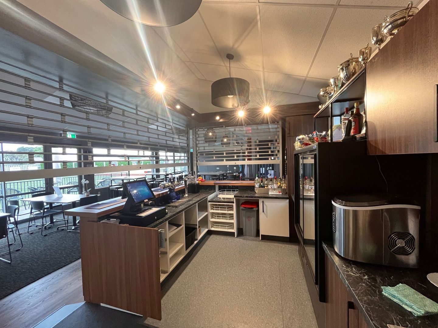 A kitchen in a restaurant with a stainless steel toaster oven.