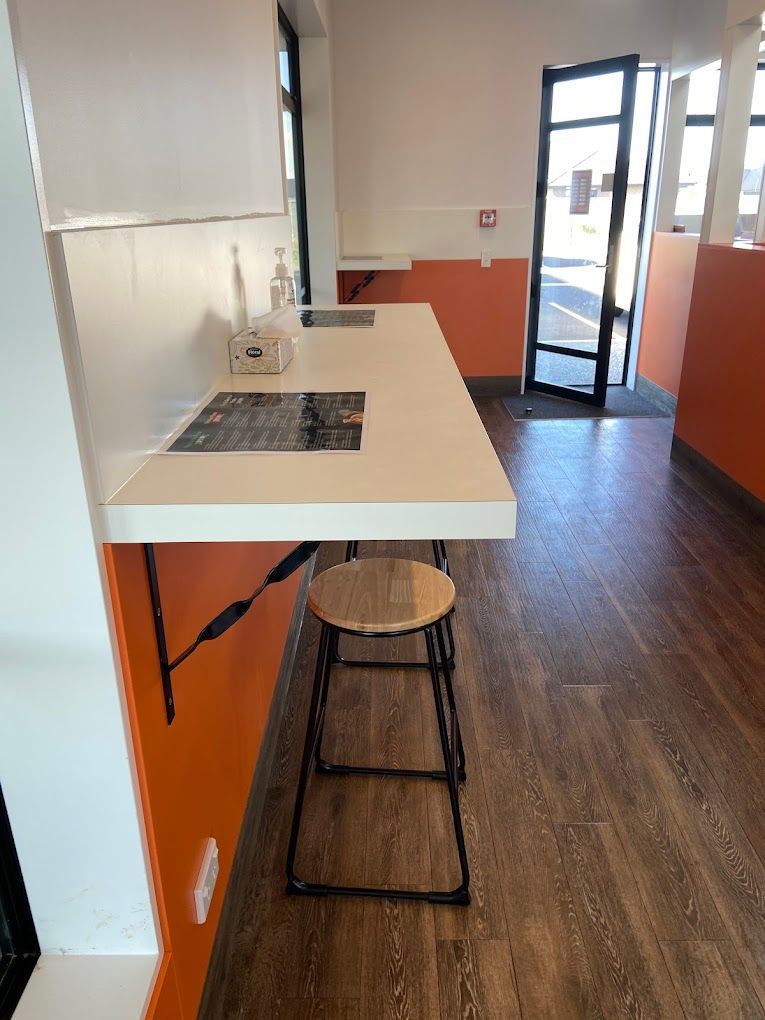 A kitchen with orange walls and a white counter top