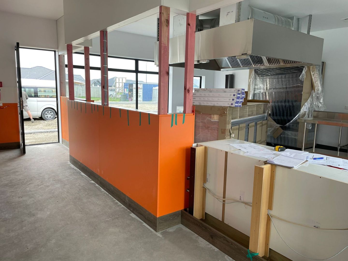 A building under construction with orange walls and a white counter.