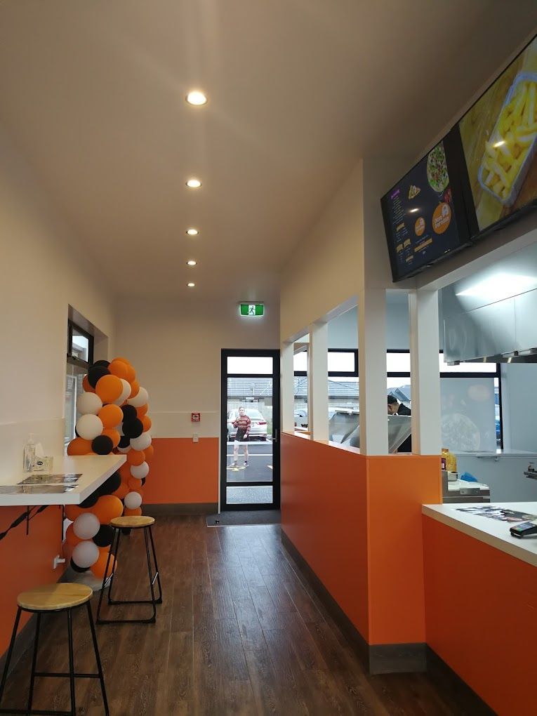 A long hallway in a restaurant with balloons on the wall