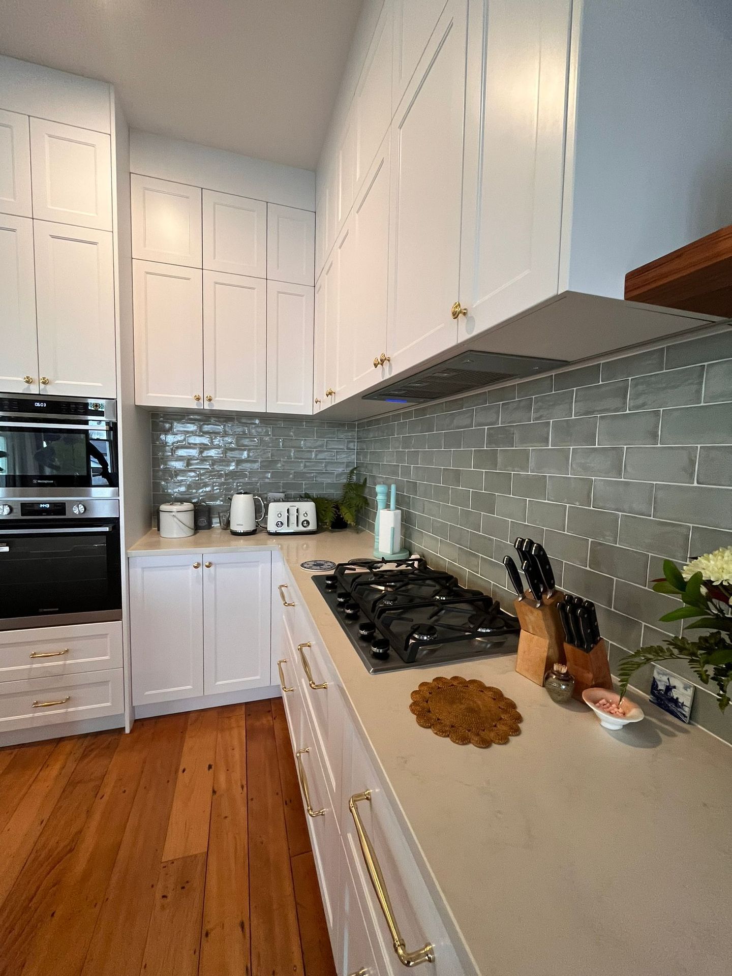 A kitchen with white cabinets and a stove top oven.