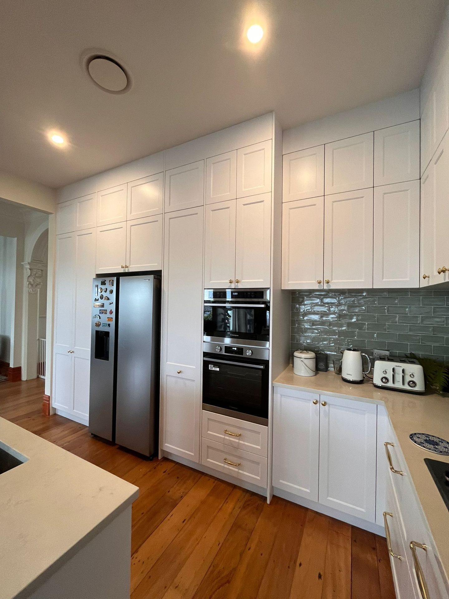 A kitchen with white cabinets and stainless steel appliances.