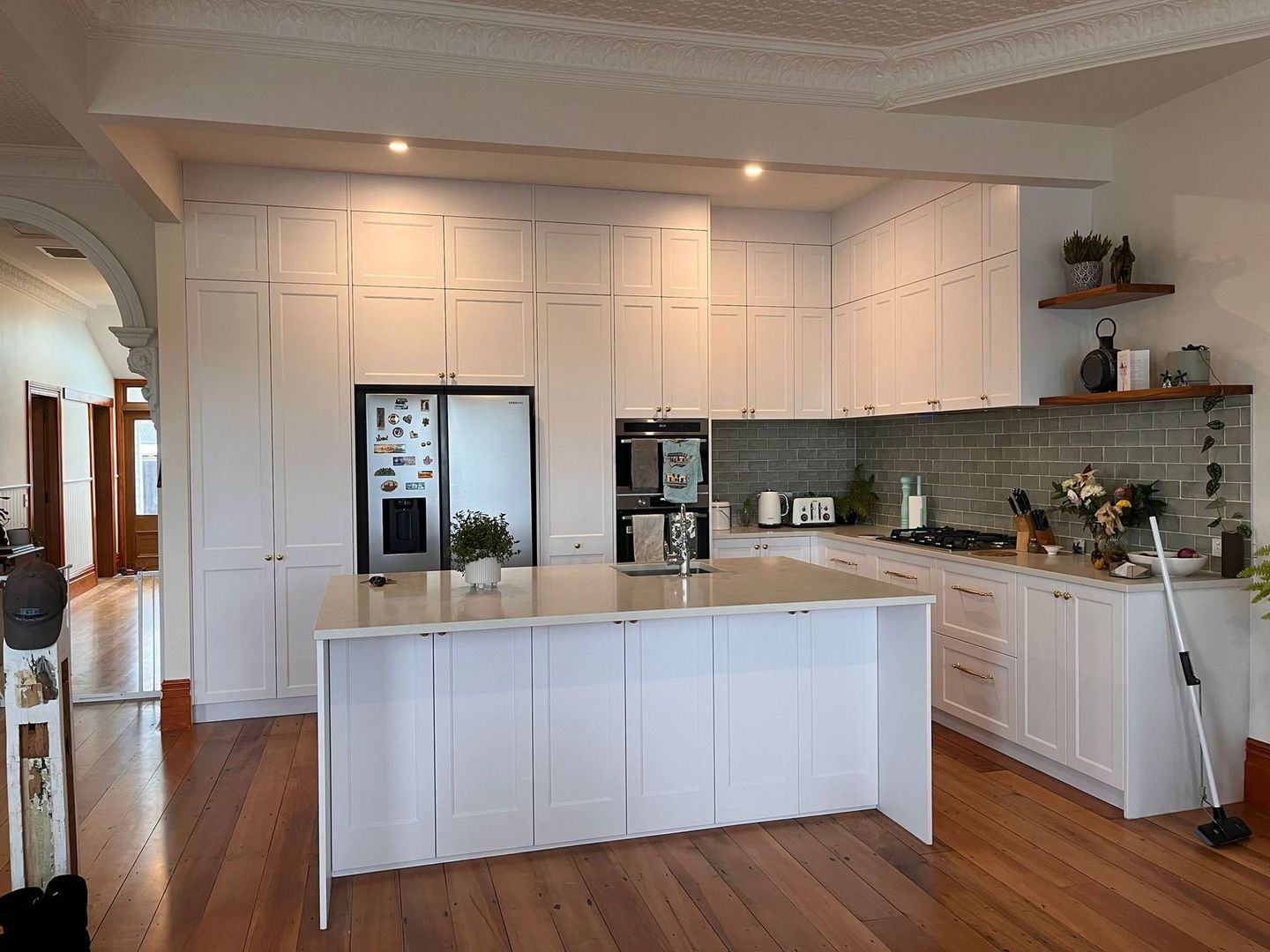 A kitchen with white cabinets and a large island in the middle.