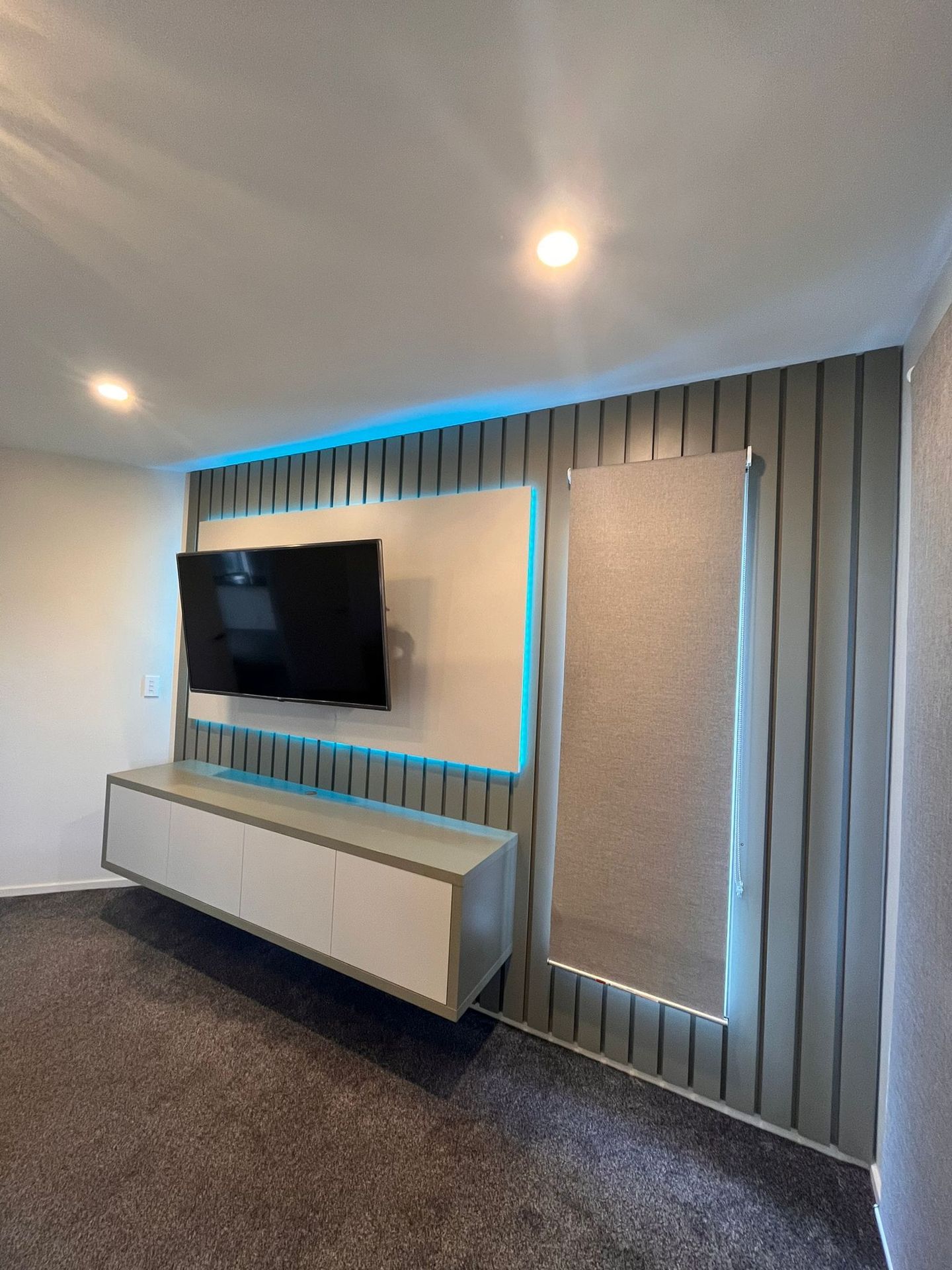 A living room with a flat screen tv mounted on the wall.