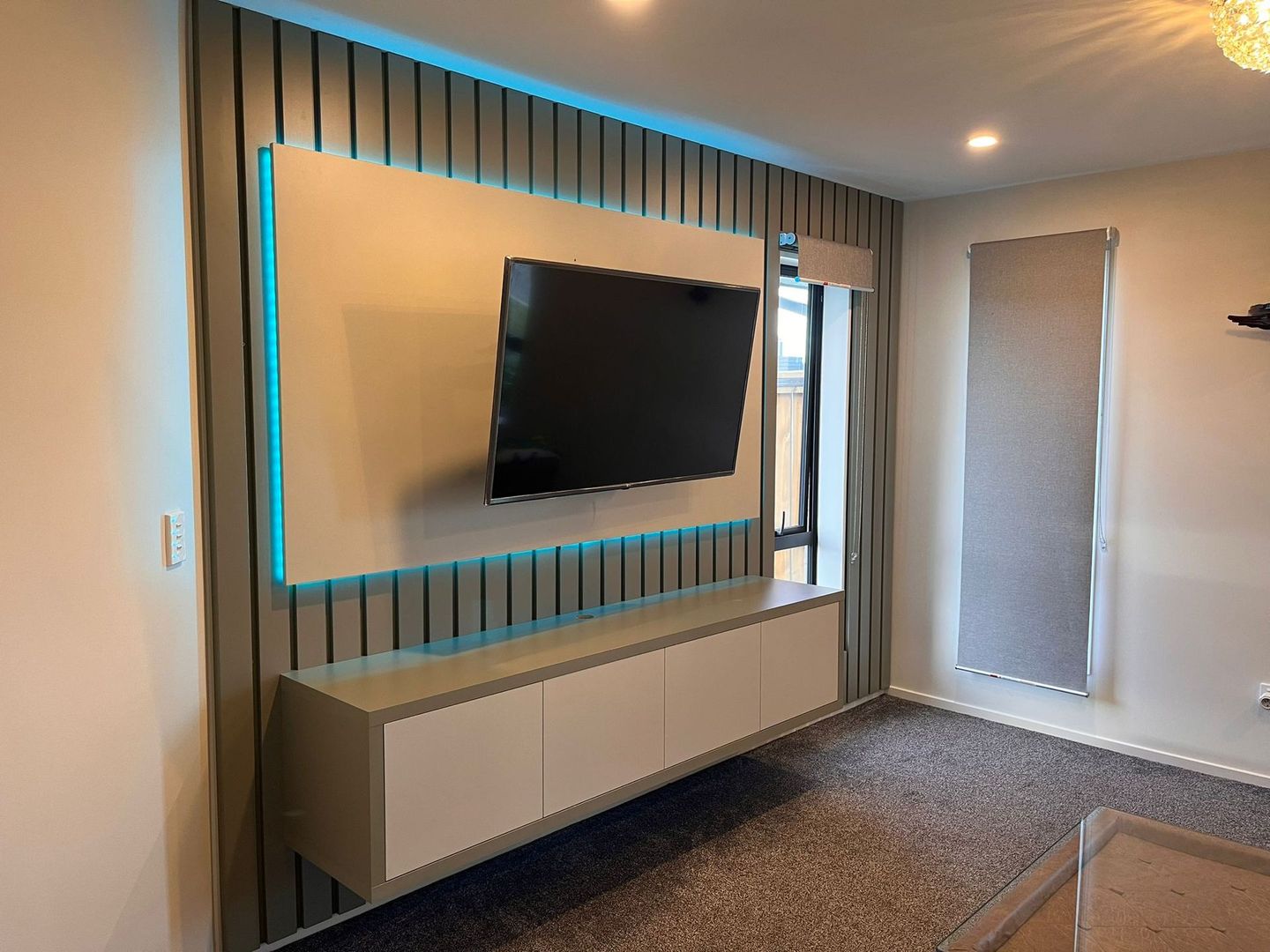 A living room with a flat screen tv mounted on the wall.