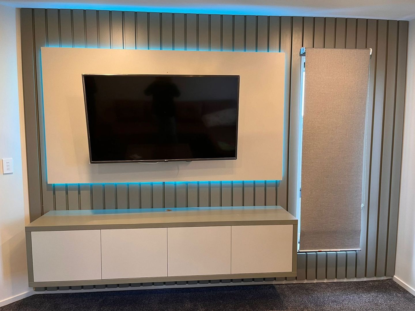 A living room with a flat screen tv mounted on the wall.