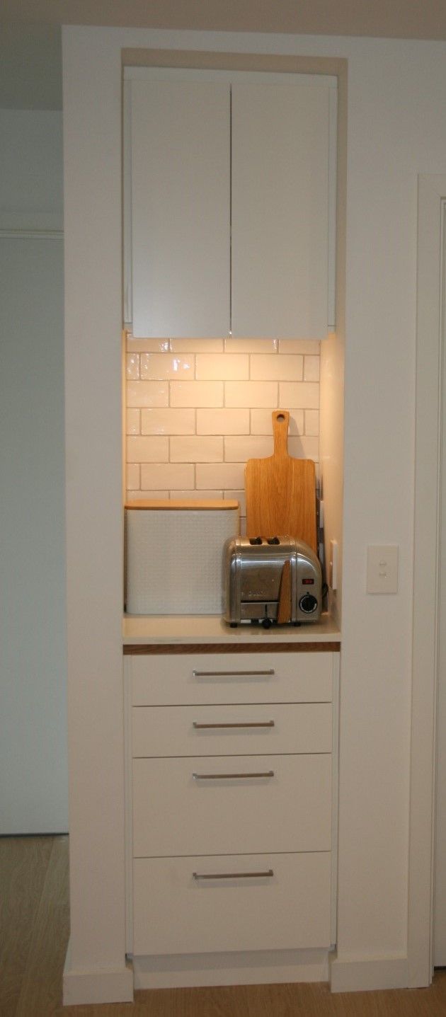 A kitchen with white cabinets and a toaster oven