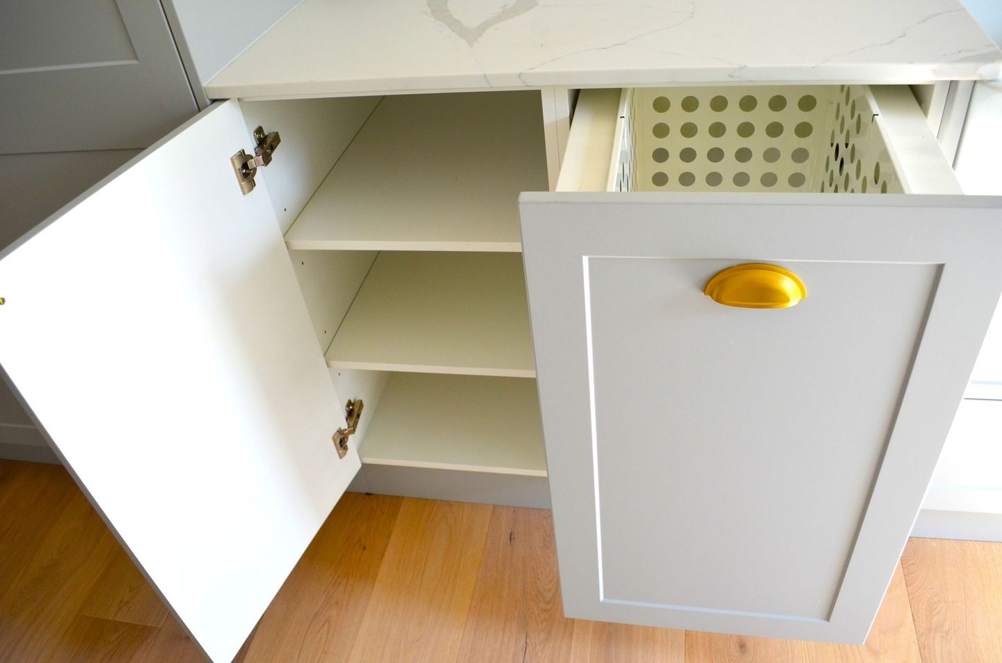 A white cabinet with a basket in the drawer