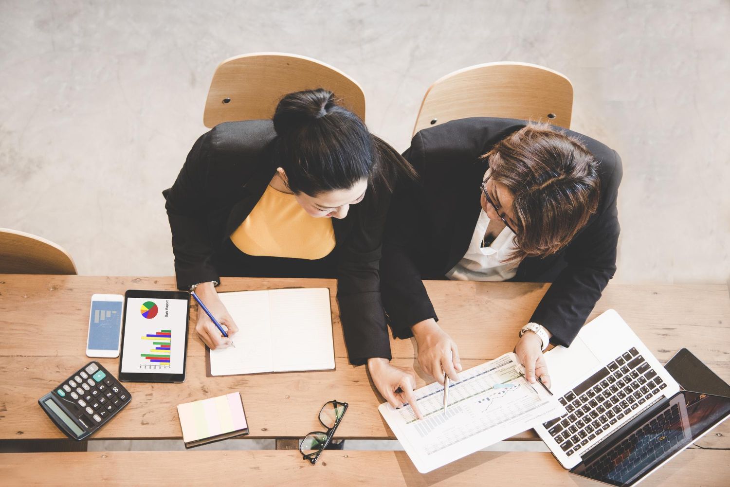 People enjoying a meal outdoors. Man grilling food, woman holding a glass. Sunlight illuminates the scene.