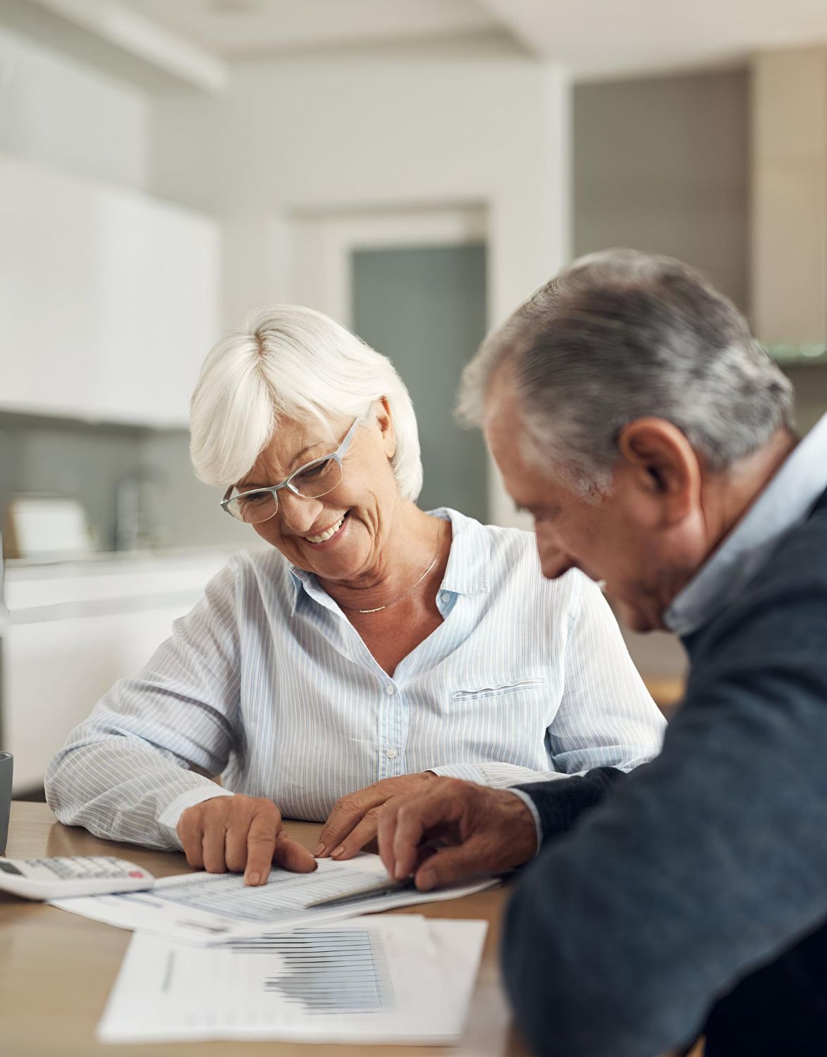 Hands stacked together with a healthcare provider in the background.